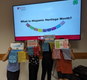 Students hold up pictures of their flags created as part of Hispanic Heritage Month